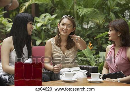 Three women at outdoor garden cafe, having a drink View Large Photo Image Stock Image - Three women at outdoor garden cafe, having a drink. Fotosearch