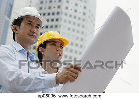 Two businessmen with blueprints, buildings in the background View Large Photo Image Stock Photograph - Two businessmen with blueprints, buildings in the background. Fotosearch