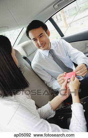 Two businesspeople in backseat of car, exchanging business cards View Large Photo Image Stock Image - Two businesspeople in backseat of car, exchanging business cards. Fotosearch