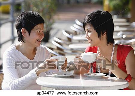 Two women in cafe having a drink View Large Photo Image Stock Photo - Two women in cafe having a drink. Fotosearch