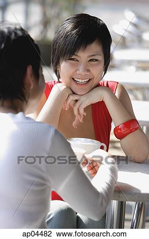 Two women in cafe, over the shoulder view View Large Photo Image Stock Image - Two women in cafe, over the shoulder view. Fotosearch