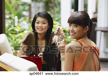 Two young women in outdoor cafe, looking at camera View Large Photo Image Stock Image - Two young women in outdoor cafe, looking at camera. Fotosearch