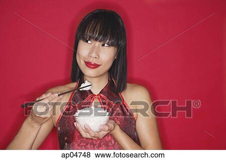 Woman against red background, holding bowl of rice View Large Photo Image Stock Photo - Woman against red background, holding bowl of rice. Fotosearch