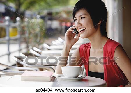 Woman at cafe using mobile phone View Large Photo Image Picture - Woman at cafe using mobile phone. Fotosearch
