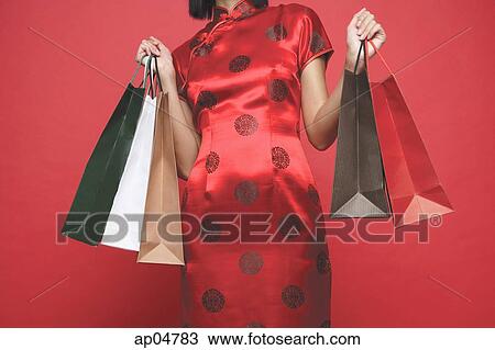 Stock Image - Woman carrying shopping bags, cropped image. Fotosearch