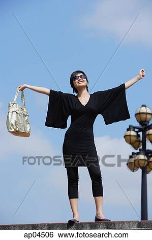 Woman dressed in black, arms outstretched View Large Photo Image Stock Photograph - Woman dressed in black, arms outstretched. Fotosearch