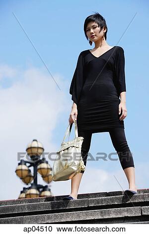 Woman dressed in black, standing on steps View Large Photo Image Stock Image - Woman dressed in black, standing on steps. Fotosearch