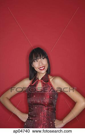 Woman dressed in cheongsam, hands on hips, smiling View Large Photo Image Stock Image - Woman dressed in cheongsam, hands on hips, smiling. Fotosearch