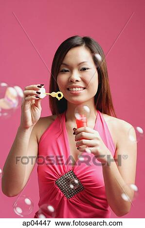 Woman dressed in pink, holding bubble wand View Large Photo Image Stock Photo - Woman dressed in pink, holding bubble wand. Fotosearch
