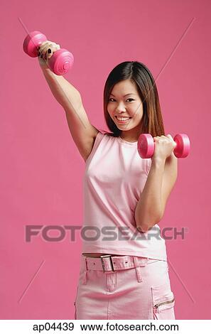 Woman dressed in pink, using dumbbells View Large Photo Image Stock Photo - Woman dressed in pink, using dumbbells. Fotosearch