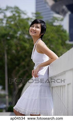 Woman dressed in white, leaning on bridge View Large Photo Image Picture - Woman dressed in white, leaning on bridge. Fotosearch