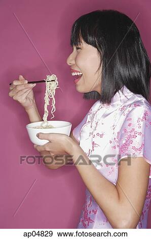 Stock Photo - Woman eating noodles. Fotosearch