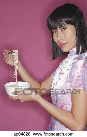 Woman holding bowl of noodles and chopsticks View Large Photo Image Stock Photo - Woman holding bowl of noodles and chopsticks. Fotosearch