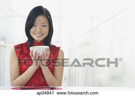 Stock Image - Woman holding bowl of rice. Fotosearch