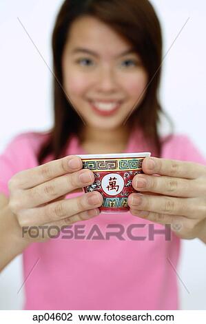 Woman holding Chinese tea cup towards camera, selective focus View Large Photo Image Stock Image - Woman holding Chinese tea cup towards camera, selective focus. Fotosearch