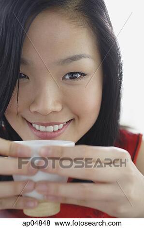 Woman holding teacup, smiling at camera View Large Photo Image Stock Photo - Woman holding teacup, smiling at camera. Fotosearch