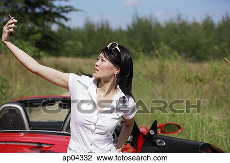 Woman holding up mobile phone, taking a picture View Large Photo Image Stock Image - Woman holding up mobile phone, taking a picture. Fotosearch