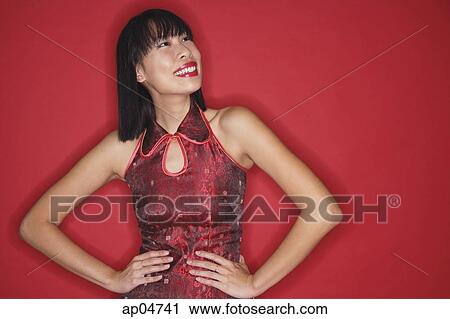 Woman in cheongsam, hands on hips, smiling, looking up View Large Photo Image Stock Image - Woman in cheongsam, hands on hips, smiling, looking up. Fotosearch