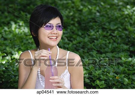 Woman in purple sunglasses, holding drink, looking away View Large Photo Image Stock Image - Woman in purple sunglasses, holding drink, looking away. Fotosearch