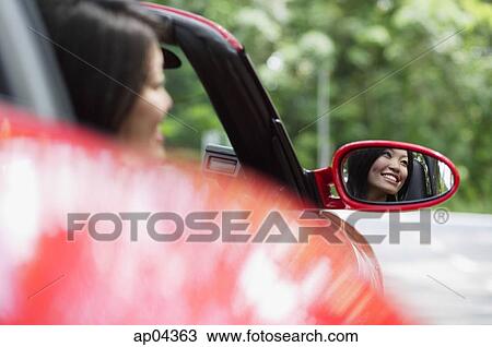 Woman in red sports car, reflected in side view mirror View Large Photo Image Stock Image - Woman in red sports car, reflected in side view mirror. Fotosearch