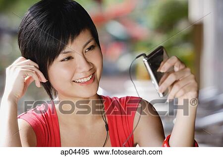 Woman listening to MP3 player View Large Photo Image Stock Photography - Woman listening to MP3 player. Fotosearch