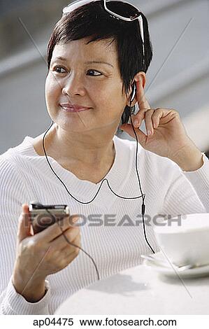 Stock Photography - Woman listening to music from an MP3 player. Fotosearch