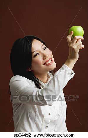 Woman looking at green apple View Large Photo Image Stock Image - Woman looking at green apple. Fotosearch