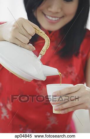 Woman pouring tea from teapot View Large Photo Image Stock Photography - Woman pouring tea from teapot. Fotosearch