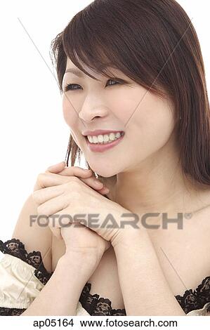 Picture - Woman, smiling, looking away, hands clasped. Fotosearch