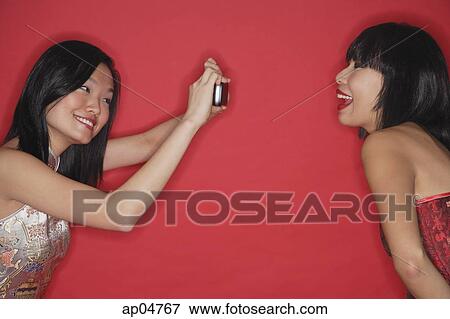 Woman taking a picture of her friend View Large Photo Image Stock Photo - Woman taking a picture of her friend. Fotosearch