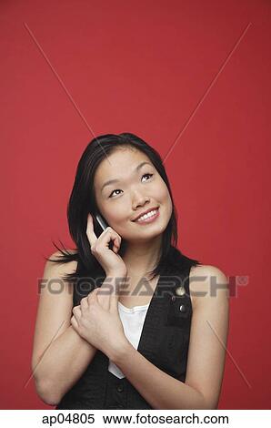 Stock Photography - Woman using mobile phone, looking up. Fotosearch
