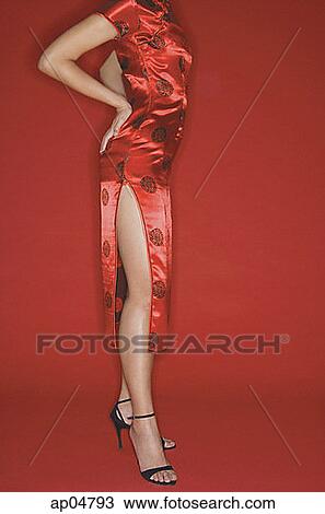 Stock Image - Woman wearing cheongsam and high heels, hands on hips. Fotosearch