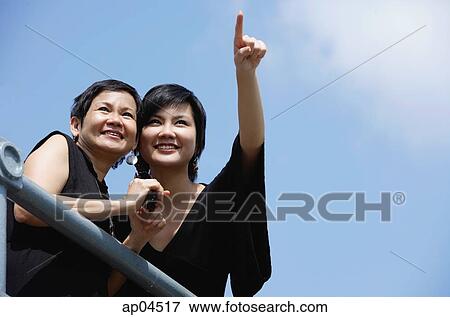 Woman with adult daughter, looking in the distance View Large Photo Image Stock Photo - Woman with adult daughter, looking in the distance. Fotosearch