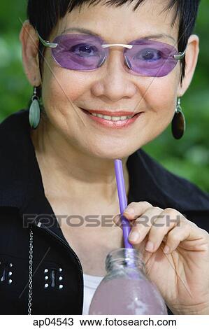 Woman with bottled drink and straw, smiling View Large Photo Image Stock Image - Woman with bottled drink and straw, smiling. Fotosearch