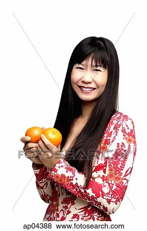 Woman with long straight hair, holding two oranges View Large Photo Image Stock Photo - Woman with long straight hair, holding two oranges. Fotosearch