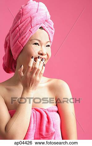 Woman wrapped in a pink towel, hand over mouth View Large Photo Image Stock Photograph - Woman wrapped in a pink towel, hand over mouth. Fotosearch