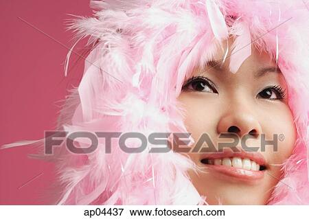 Stock Photo - Woman's face surrounded by pink feathers. Fotosearch