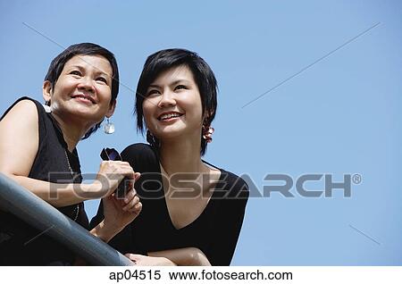 Women side by side, smiling, looking away View Large Photo Image Stock Photography - Women side by side, smiling, looking away. Fotosearch
