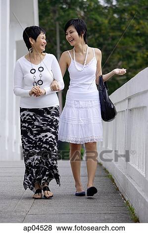 Women walking side by side, arm in arm View Large Photo Image Stock Photo - Women walking side by side, arm in arm. Fotosearch