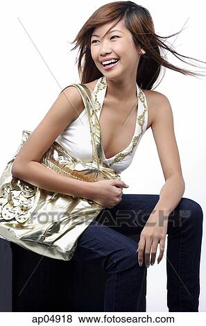 Young woman carrying gold bag, smiling View Large Photo Image Stock Photo - Young woman carrying gold bag, smiling. Fotosearch