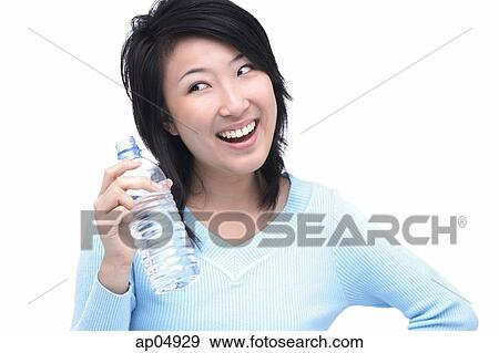 Young woman holding bottle of water, looking away View Large Photo Image Stock Photo - Young woman holding bottle of water, looking away. Fotosearch