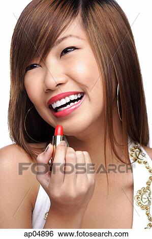 Stock Photograph - Young woman holding lipstick. Fotosearch