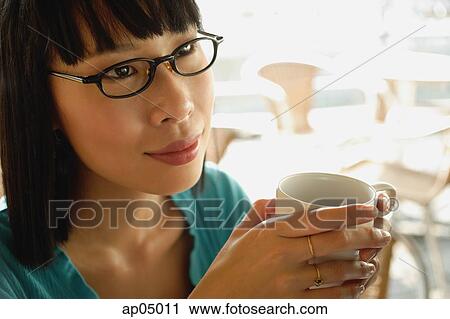 Young woman in black glasses, with coffee cup View Large Photo Image Stock Image - Young woman in black glasses, with coffee cup. Fotosearch