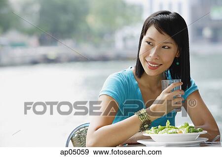 Young woman in cafe, looking away, smiling View Large Photo Image Stock Photo - Young woman in cafe, looking away, smiling. Fotosearch