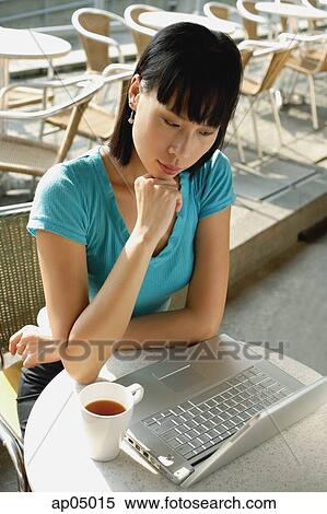Young woman in cafe using laptop View Large Photo Image Stock Photography - Young woman in cafe using laptop. Fotosearch