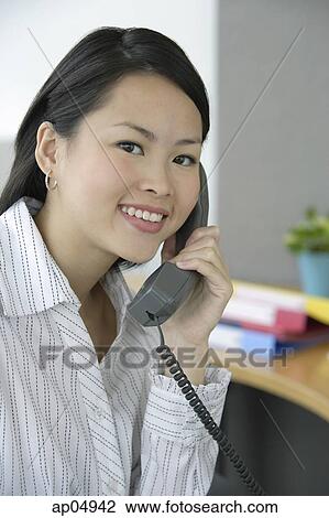 Young woman in office using telephone, portrait View Large Photo Image Stock Image - Young woman in office using telephone, portrait. Fotosearch
