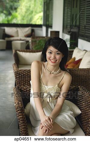 Young woman in sleeveless dress smiling at camera View Large Photo Image Stock Image - Young woman in sleeveless dress smiling at camera. Fotosearch