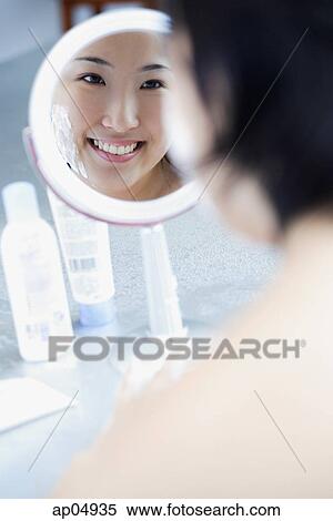 Young woman looking in mirror, over the shoulder view View Large Photo Image Stock Photography - Young woman looking in mirror, over the shoulder view. Fotosearch