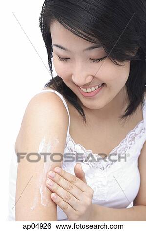 Young woman putting moisturizer on arm View Large Photo Image Stock Photograph - Young woman putting moisturizer on arm. Fotosearch