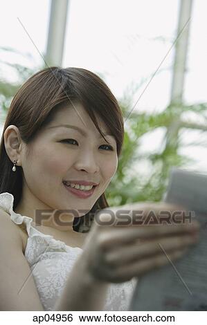 Young woman reading a book, selective focus View Large Photo Image Stock Photograph - Young woman reading a book, selective focus. Fotosearch